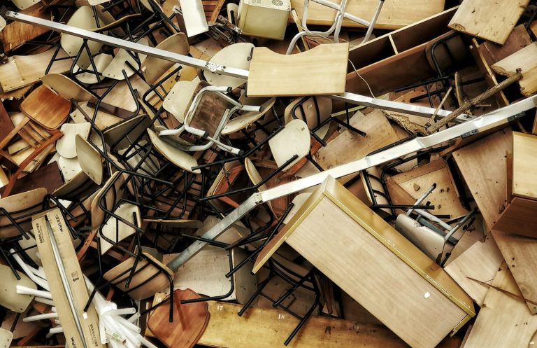 Ein Haufen Möbel und Stühle, chaotisch übereinander gestapelt.