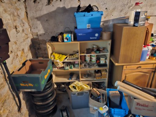 Keller mit Regalen voller Kisten, Werkzeug und verschiedenen Haushaltsgegenständen.