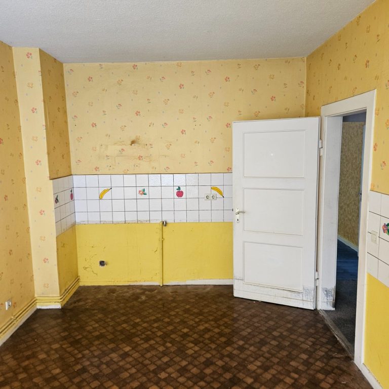 Leeres Zimmer mit gelben Wänden, Fliesen und einem offenen Türblock.